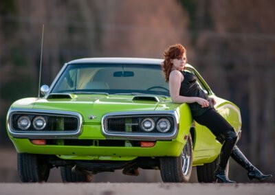 “1968 lime green Super B classic car photographed on an open road with distant trees as a contrasting background, late evening light highlighting the car’s lines, with a model leaning against it, captured by David Thielen Photographic Artistry”