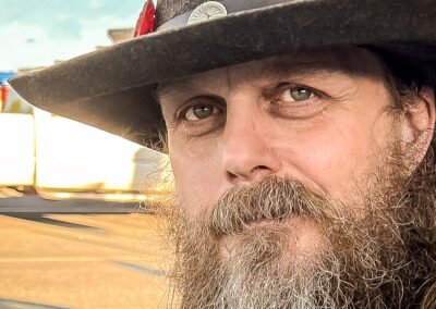 “Close-up horizontal portrait of a bearded man wearing a hat, captured spontaneously in a Walmart parking lot by David Thielen Photographic Artistry”